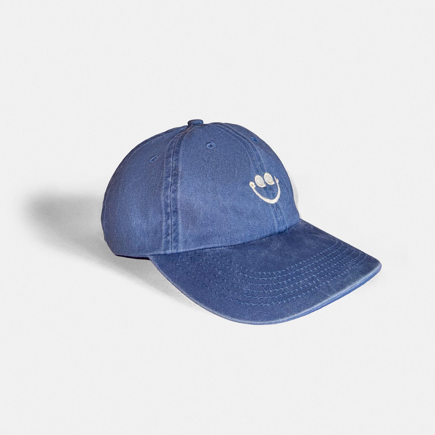 Blue denim cap with a white CQQL Records smiley face logo on a light gray background